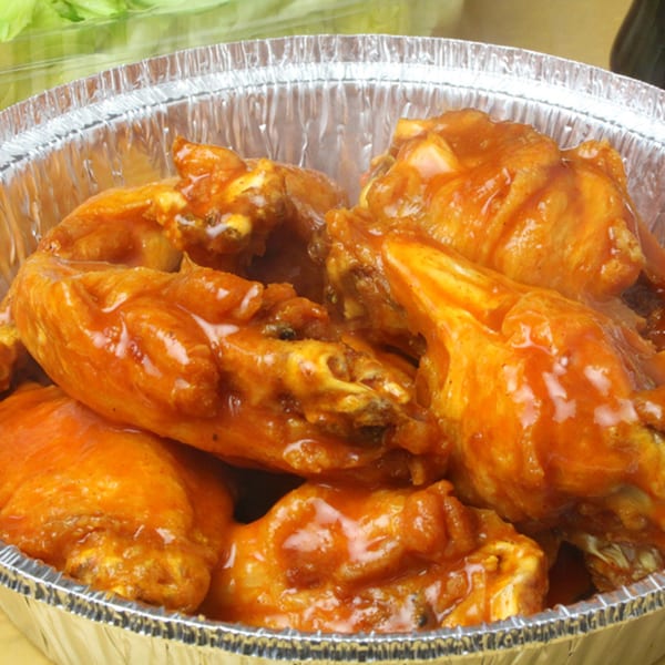 Mama Gina's Pizzeria buffalo wings in a foil container, with a side of lettuce.